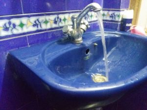 repairing a faucet in a washing basin