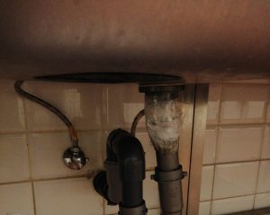 unclogging a kitchen drain pipe