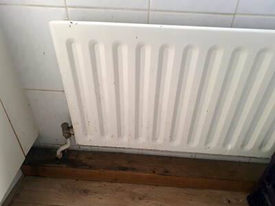 Old radiator with visible dirt and rust buildup that requires maintenance.